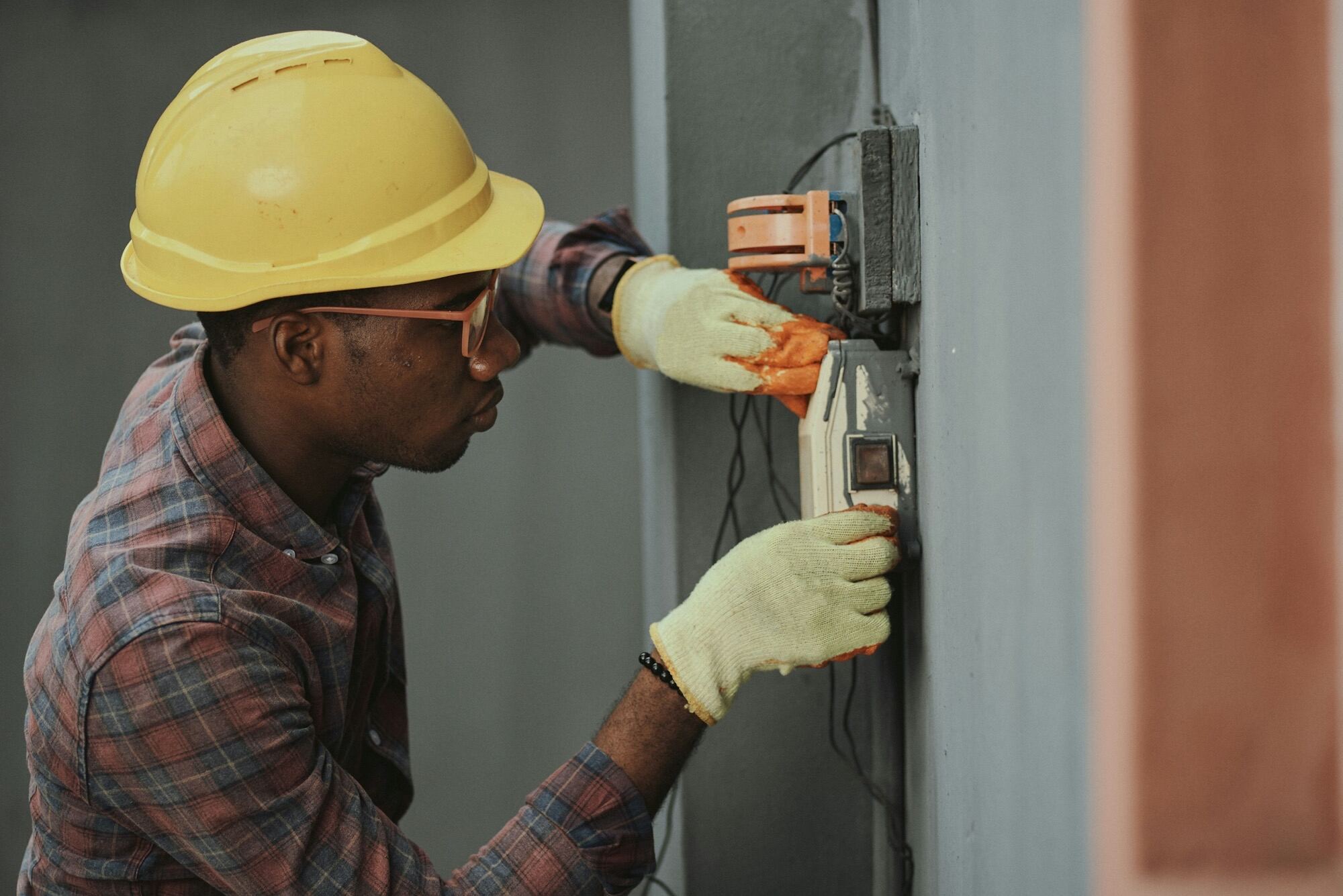 Ouvrier du bâtiment intervenant sur une installation électrique sur un chantier de construction